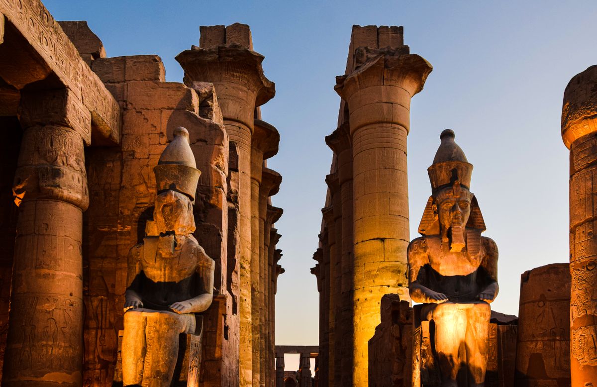 Beleuchtete Statuen Ramses’ II. im Luxor-Tempel am Abend